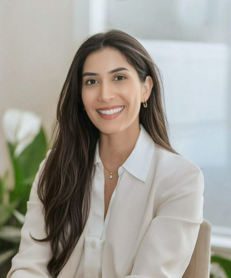 Smiling dentist in white blouse seated indoors at Dental Excellence of Brandon