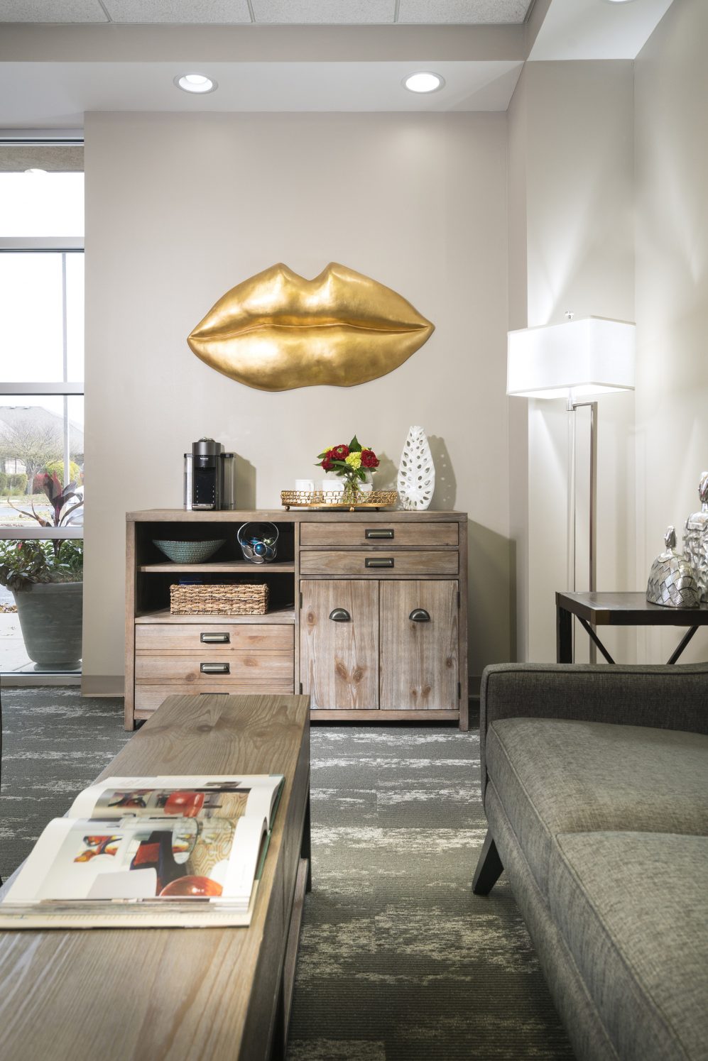 Lounge area with decorative gold lip art and coffee station at Springfield Smile Doctor