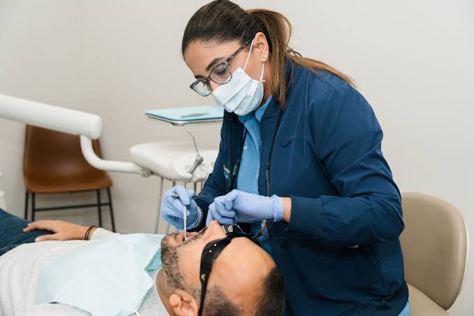 Dental hygienist cleaning a patient's teeth in treatment room at Smile4Ever Family Dentistry