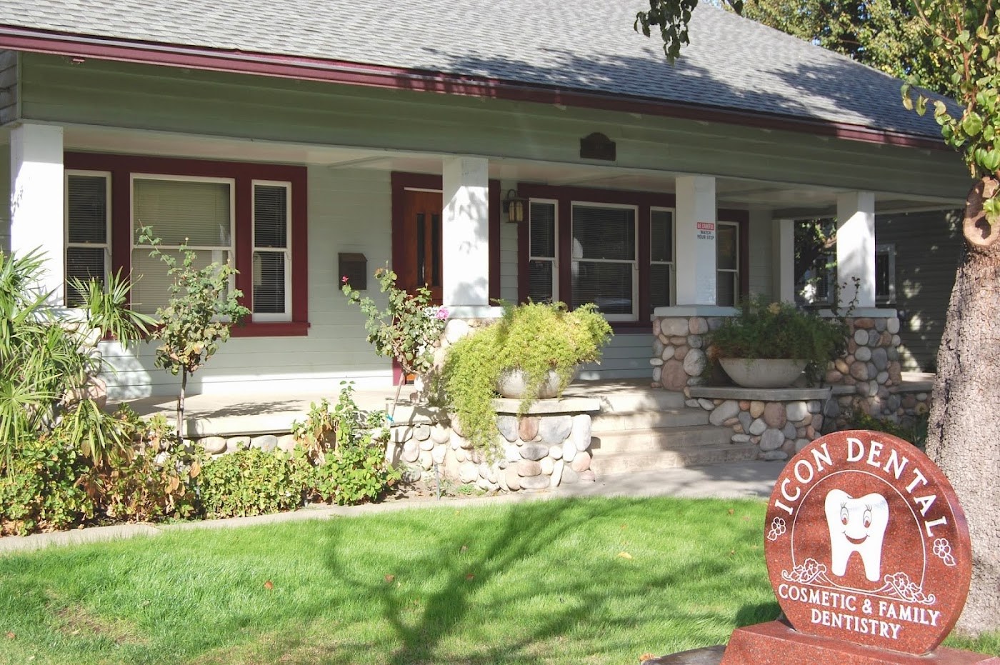 Exterior view of Icon Dental Sedation and Implants Center in Visalia, CA with signage and porch