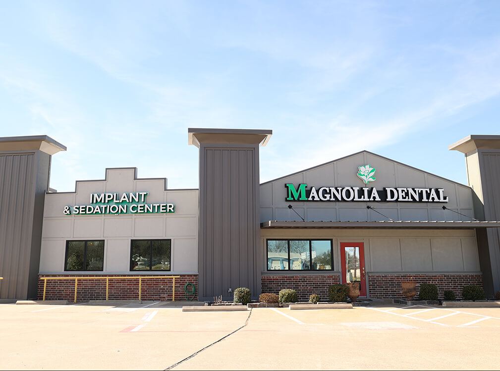 Exterior of Magnolia Dental office building with Implant & Sedation Center signage in Mabank, TX
