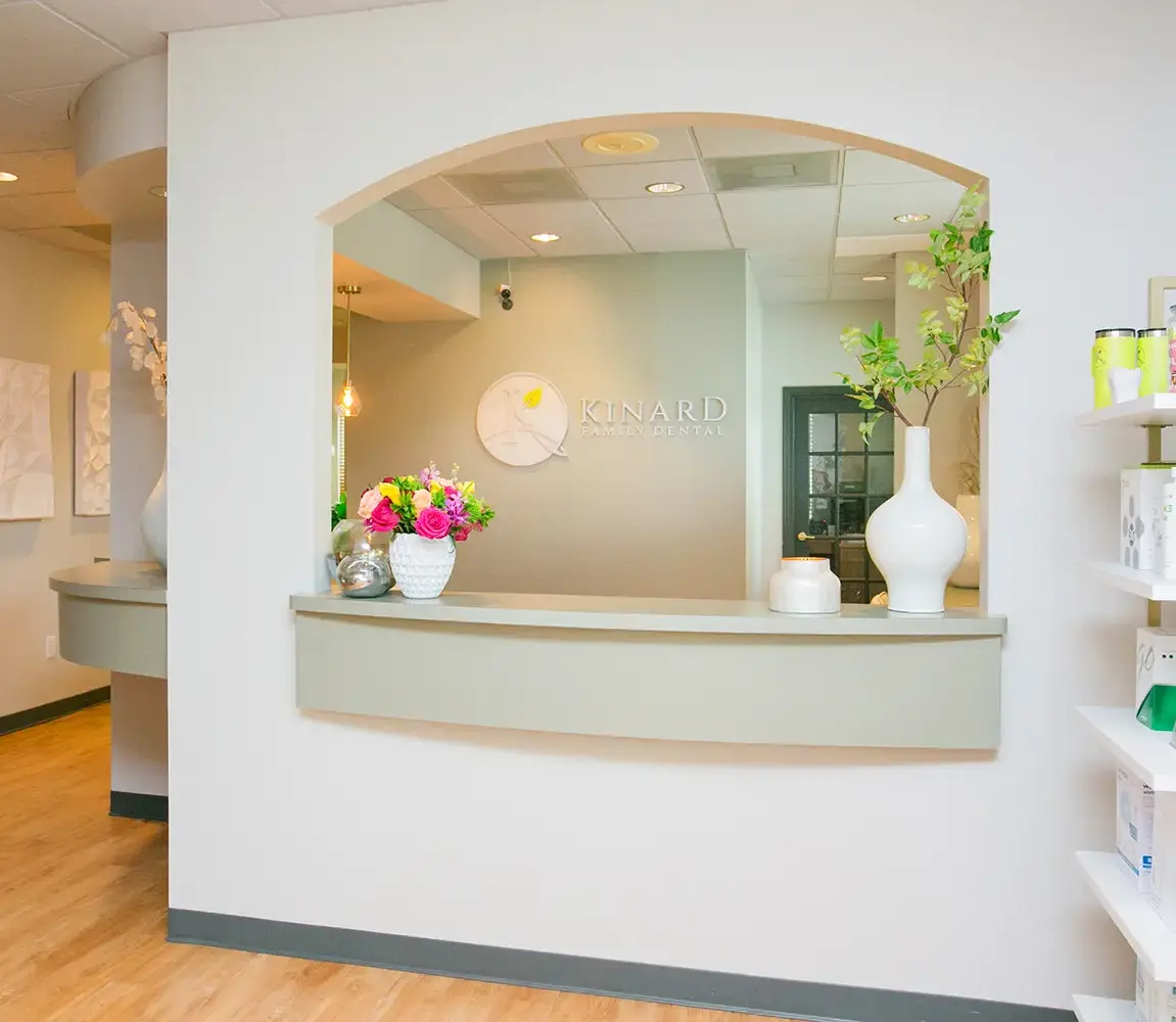 Reception desk with Kinard Family Dental sign and floral decor in Helotes, TX