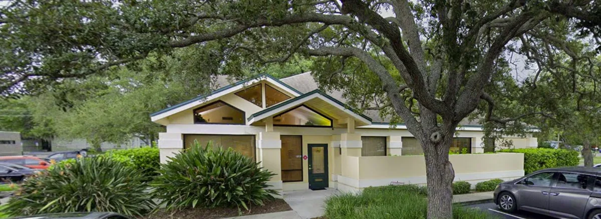 Exterior of Christopher Cannady dental office in Clearwater, FL, surrounded by trees and parking area