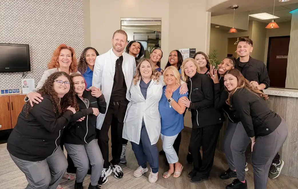 Dentist and staff posing together near the front desk at Modern Dental Care in Las Vegas