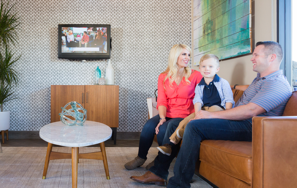 Family sitting on a couch in the waiting area at Modern Dental Care in Las Vegas