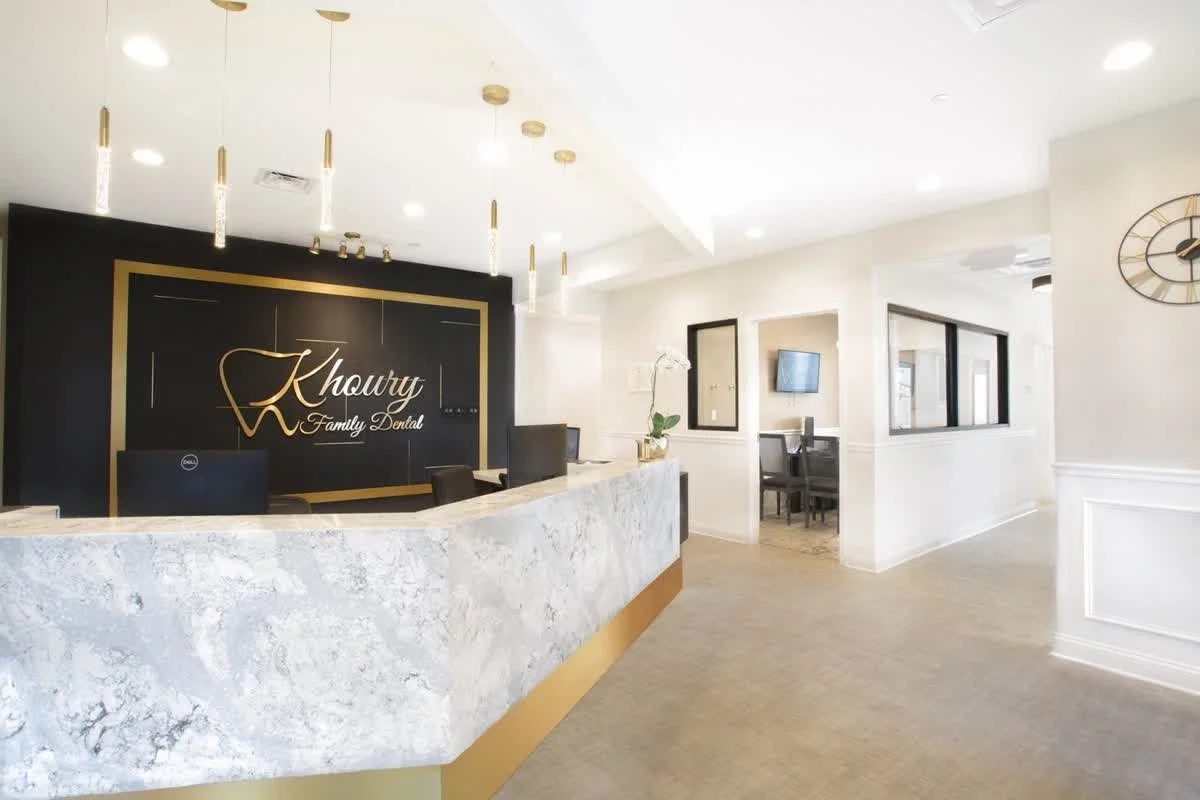 Reception counter and Khoury Family Dental logo wall in lobby