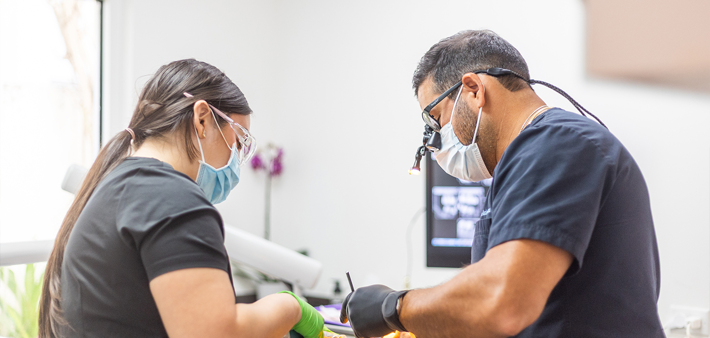 Dentist and assistant performing a procedure on a patient at Palm Beach Dental Excellence