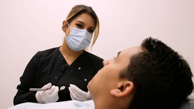 Close-up of a dental assistant checking a patient's teeth at Amani Pediatric Dentistry
