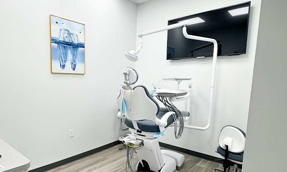 Dental operatory with chair, light, and wall art at Double Tree Dentistry in Magnolia, TX