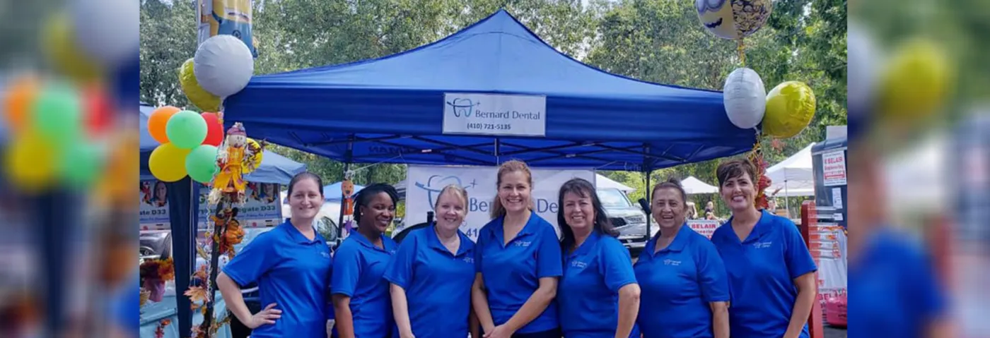 Bernard Dental team in blue polos at a community event booth in Crofton, MD