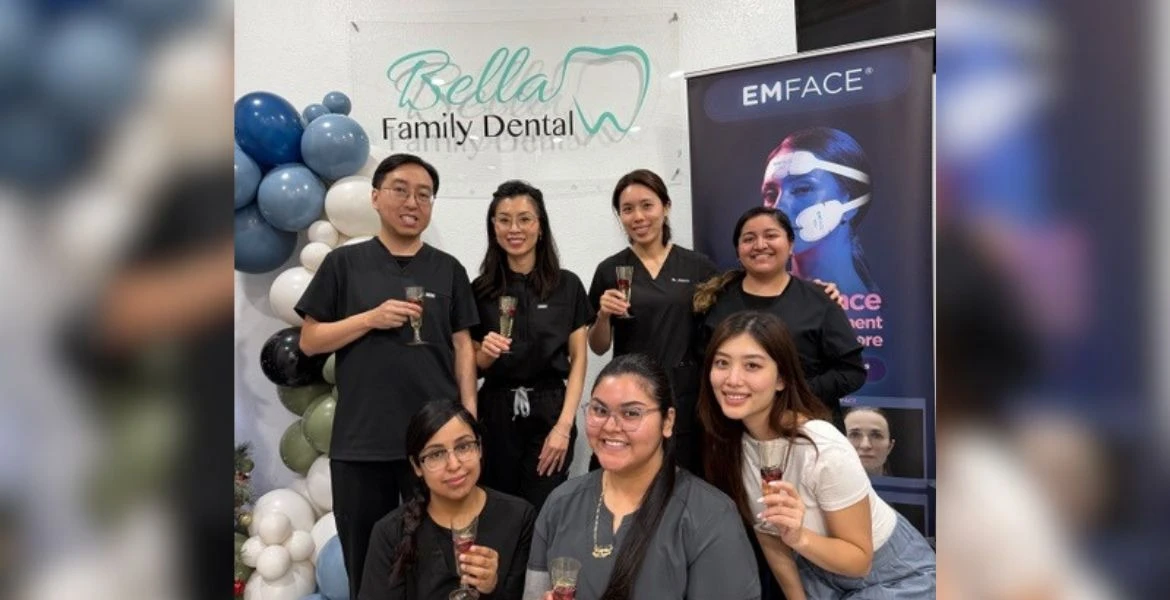 Team of dentists and staff posing together under the Bella Family Dental sign in Dallas, TX