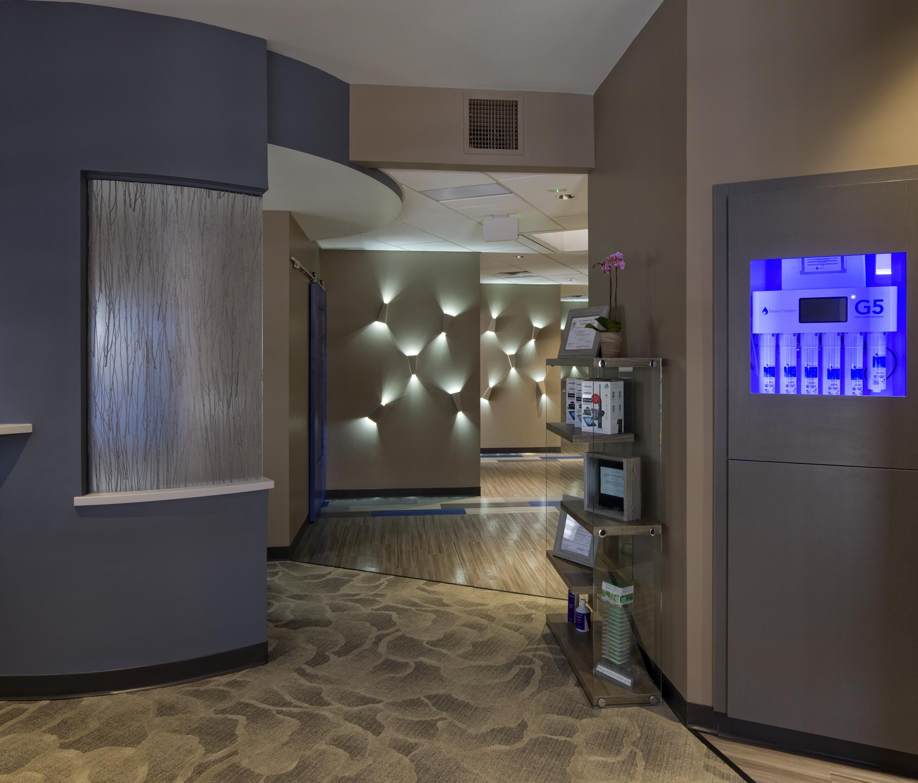 Interior hallway with water filtration display and decorative lighting at Sharpe Dental Studio