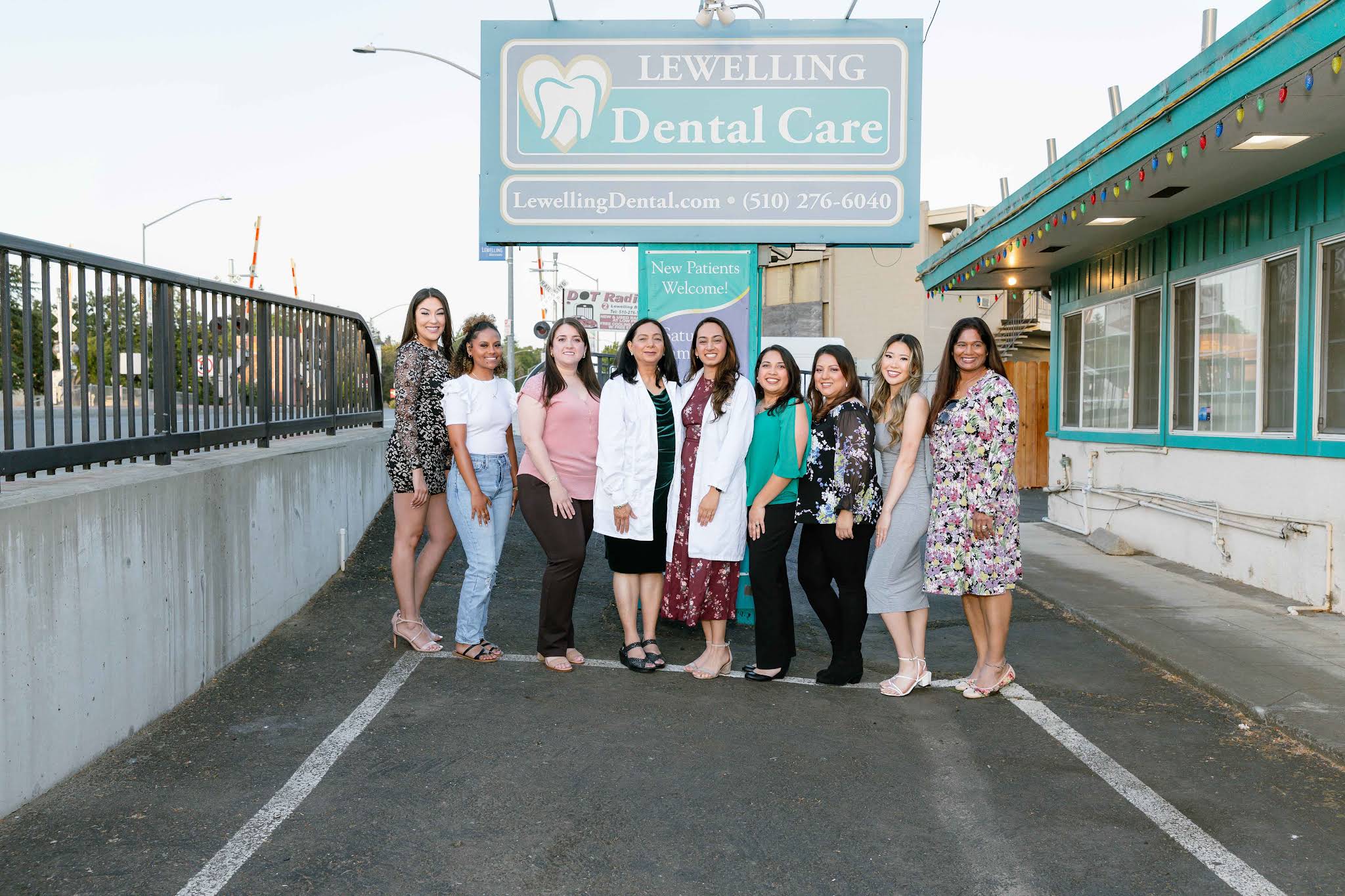 Team of staff and dentists standing under the Lewelling Dental Care sign in San Lorenzo