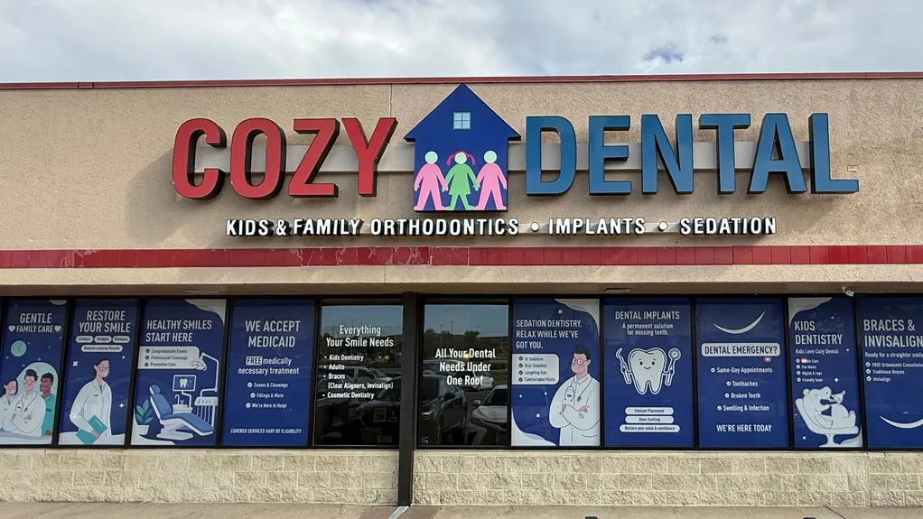 Cozy Dental building facade with illuminated sign and window ads