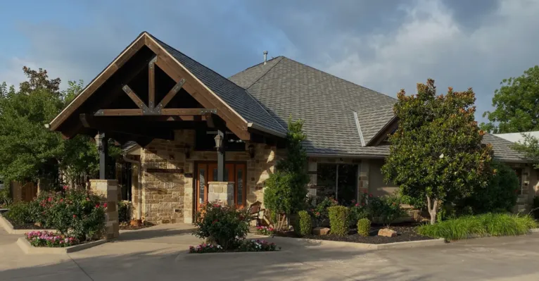 Exterior view of Four Seasons Dental PA office with stone entrance and greenery