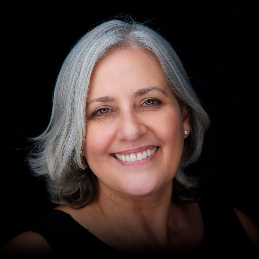 Portrait of a smiling dentist with gray hair at Muna Strasser in Moline, IL