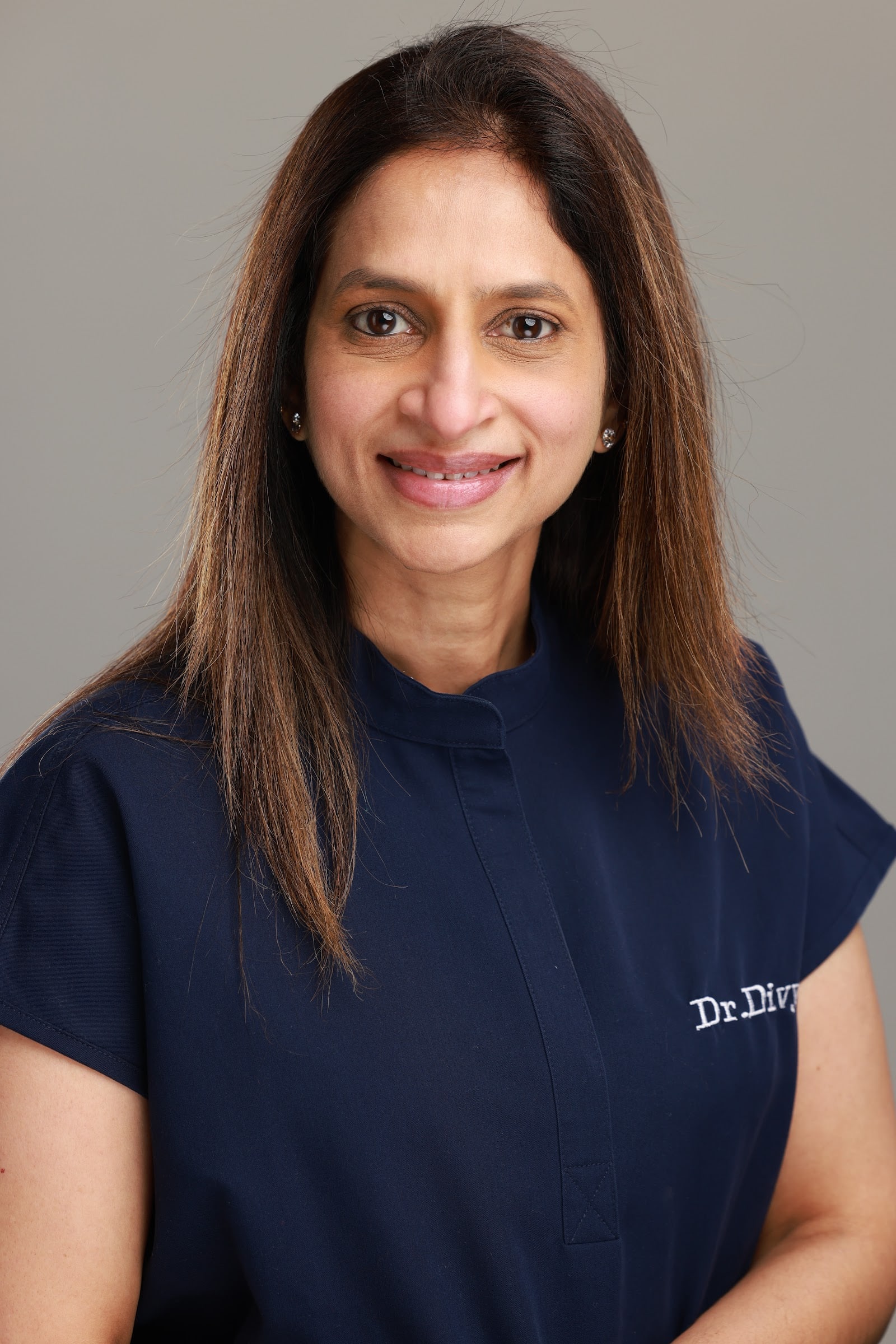 Portrait of a female dentist in navy scrubs at Esthetix Dental Spa in New York