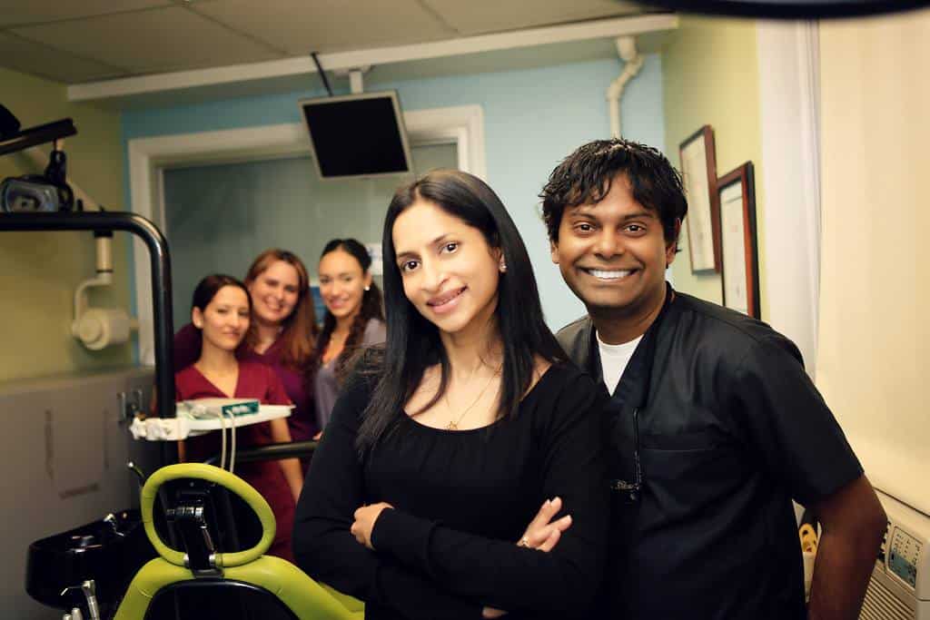 Dentist and staff posing together in a treatment room at Esthetix Dental Spa in New York